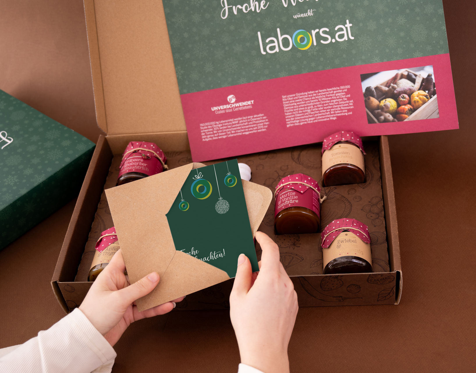 Offener geschenkkarton mit Unverschwendet-Aufstrichgläsern und Karte (von oben ) Offener geschenkkarton mit Unverschwendet-Aufstrichgläsern und Karte