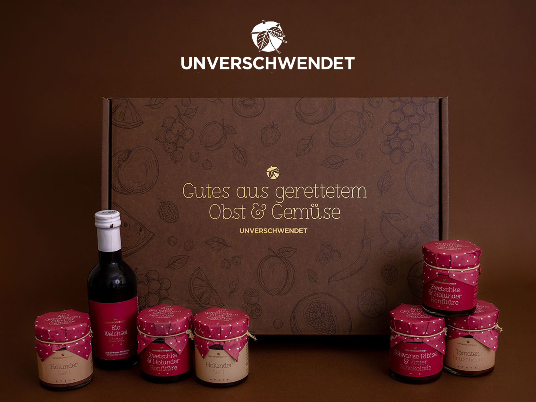 Unverschwendet Geschenkbox mit Brotaufstrich Gläschen und Weichsel Sirup Vorderansicht Unverschwendet Geschenkbox mit Brotaufstrich Gläschen und Weichsel Sirup